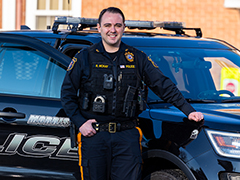 Lt. Ryan McKay poses in front of police vehicle